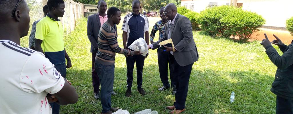 The Chief Administrative Officer - Mr. Obong Thomson (Right) handing over footballs and Netballs to various clubs from different Sub Countries and Town Councils of Lamwo District. The exercise was funded by the Education Department through the by District Sports Officer - Mr. Oweka George (Centre).